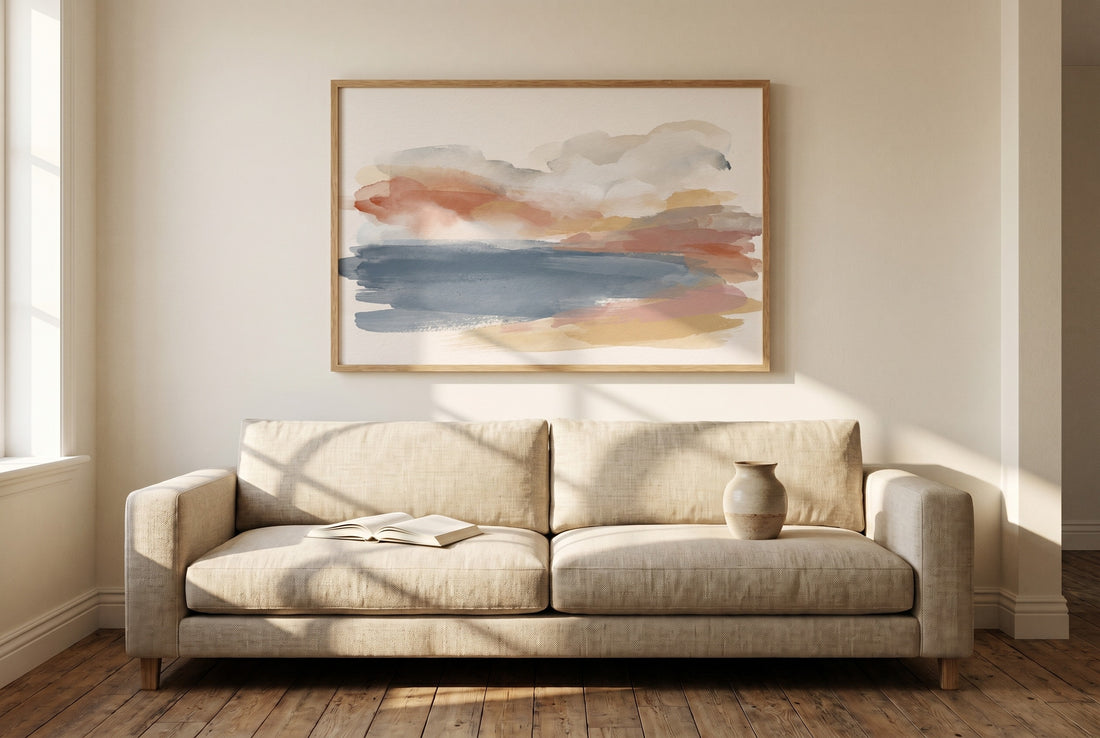 A single large framed art print correctly scaled above a linen sofa
