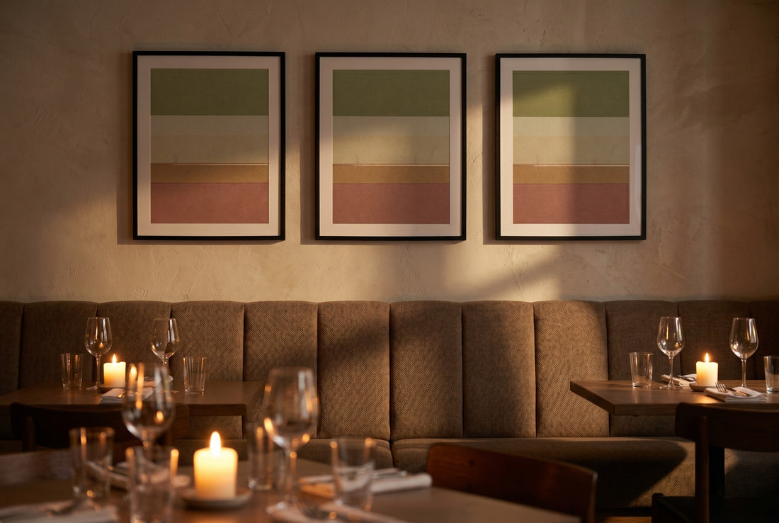 A rhythmic series of matching framed prints above a restaurant banquette