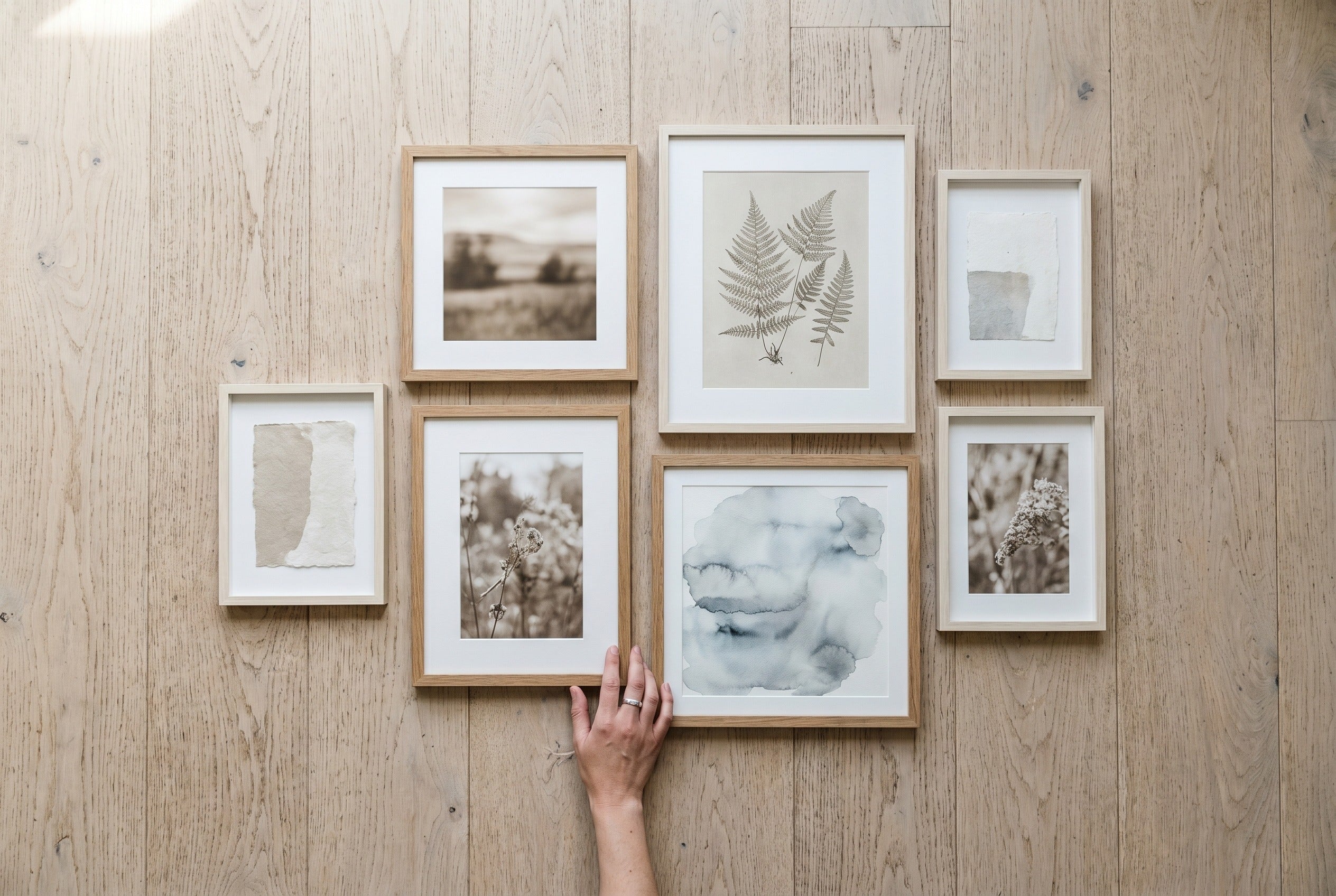 Framed prints laid out on the floor to plan a gallery wall